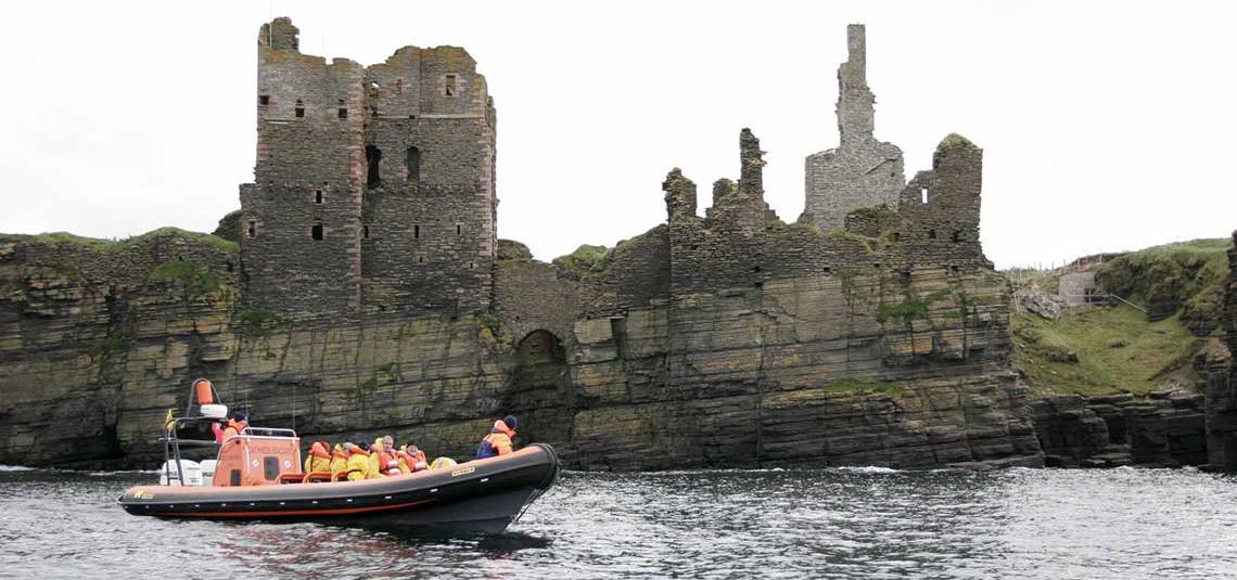 Castle Sinclair Girnigoe in the background with Caithness Seacoast Boat Tours
